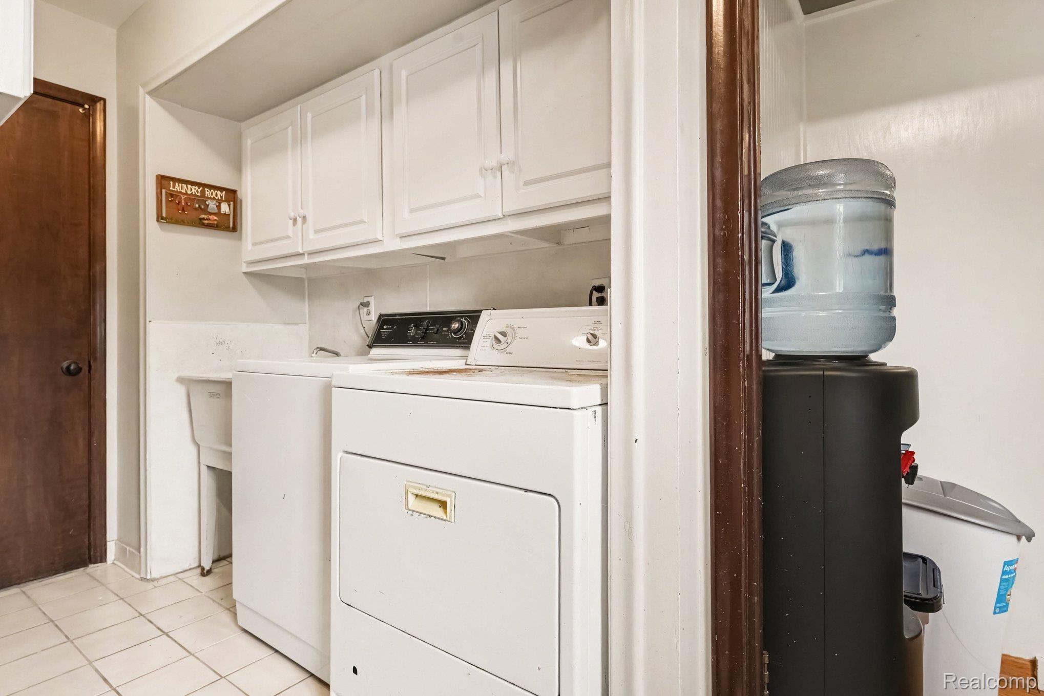 107 Michelle Drive Romeo, MI 48065 - Photo 24 of 30 Laundry area with white cabinetry, a utility sink, and tiled flooring