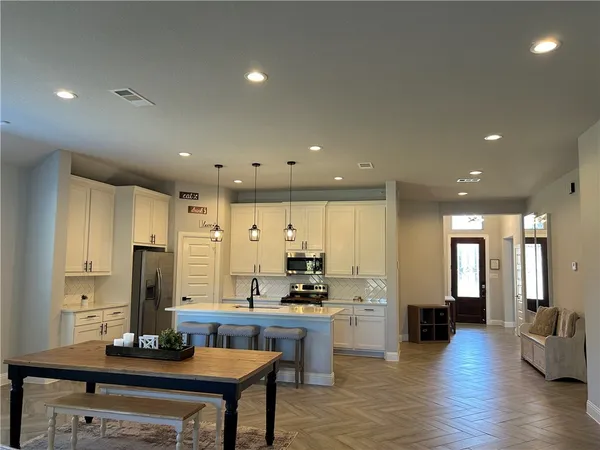 a kitchen with stainless steel appliances granite countertop a sink refrigerator and cabinets