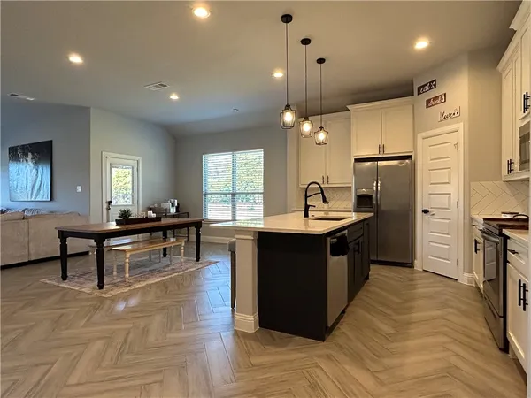 a living room with lots of furniture and kitchen view