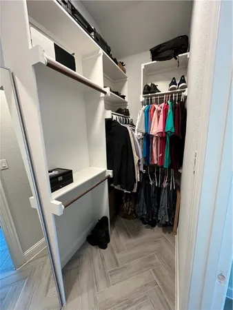 a view of walk in closet with clothes and shoes