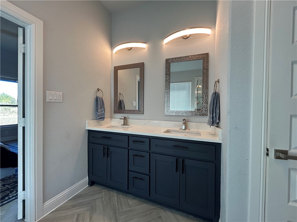 16664 County Road 3120 Road Northwest Purdon, TX 76679 - Photo 6 of 59 a bathroom with a double vanity sink and a mirror