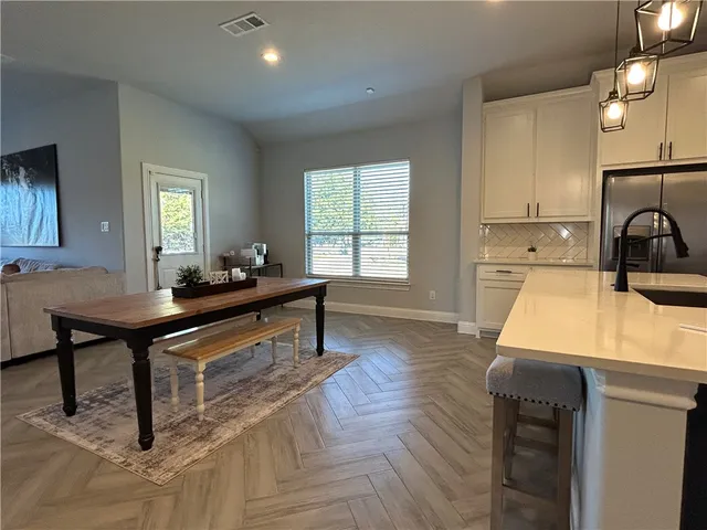 a view of a hallway with wooden floor and cabinet