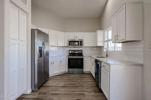 a kitchen with stainless steel appliances granite countertop a refrigerator and a stove top oven