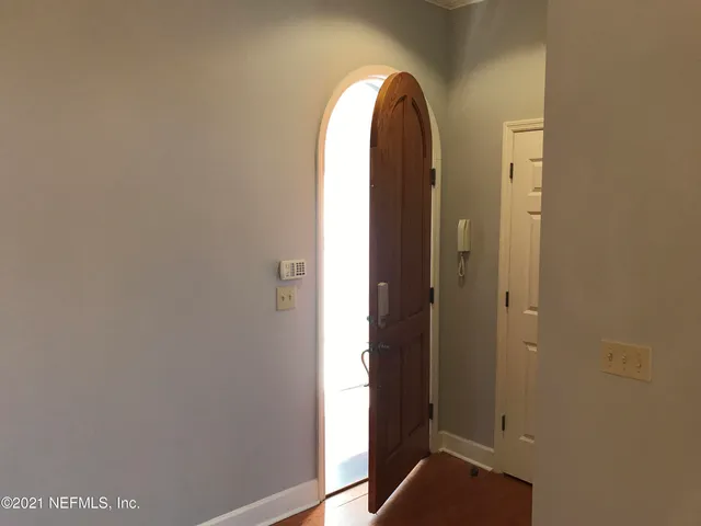 a kitchen with kitchen island granite countertop a stove top oven a sink dishwasher a refrigerator and cabinets with wooden floor