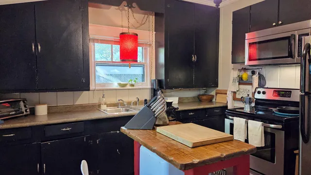 a kitchen with a sink cabinets and wooden floor