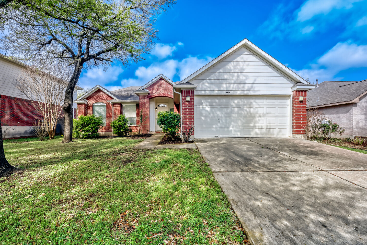 700 Runners Ridge Pflugerville, TX 78660 - Photo 1 of 1 Ranch-style house with an attached garage, brick siding, driveway, and a front yard