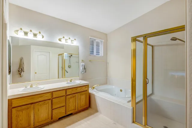 a spacious bathroom with a tub sink and mirror
