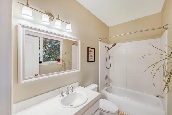 a bathroom with a granite countertop sink a toilet and shower