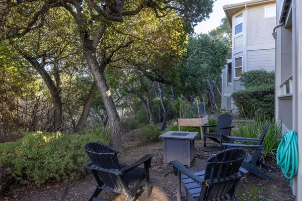 a view of a patio with table and chairs potted plants and a large tree