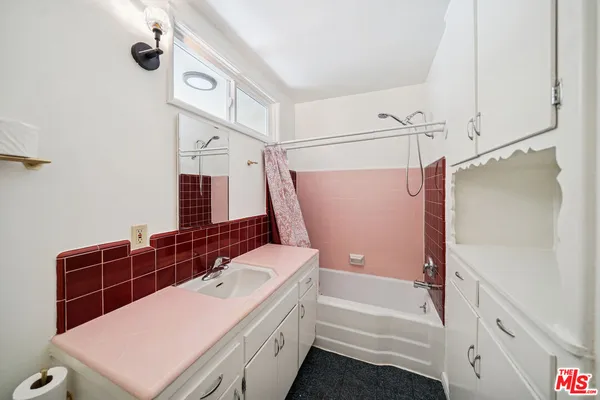 a bathroom with a tub sink and mirror