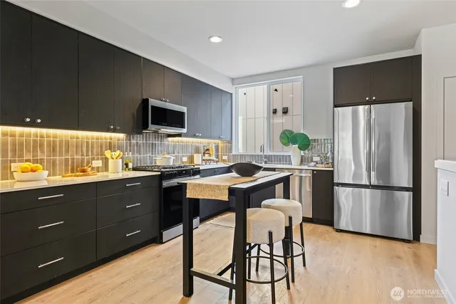 a kitchen with a dining table chairs and flat screen tv