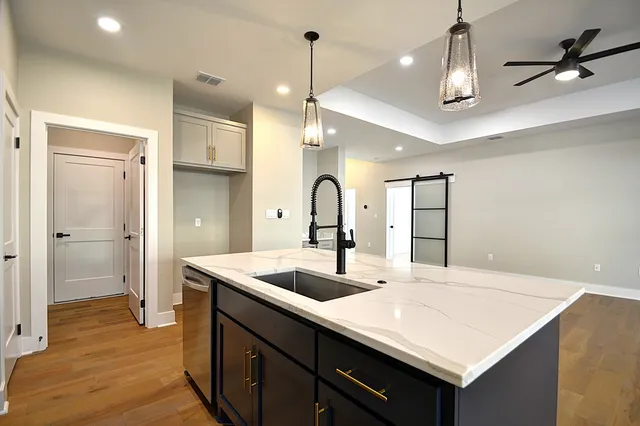 a kitchen with center island a sink appliances and wooden floor