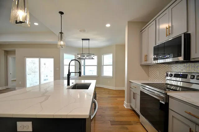a kitchen with kitchen island a sink appliances and cabinets