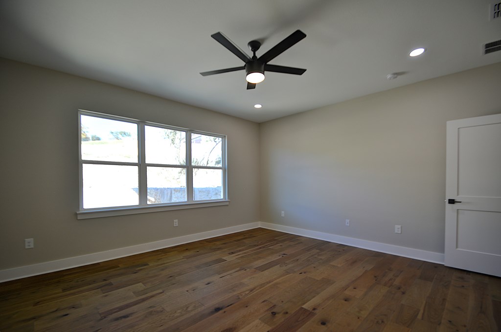 1806 Chateau Kerrville, TX 78028 - Photo 19 of 44 an empty room with wooden floor fan and windows