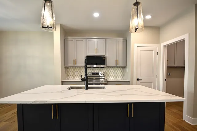 a kitchen with kitchen island a sink stainless steel appliances and cabinets