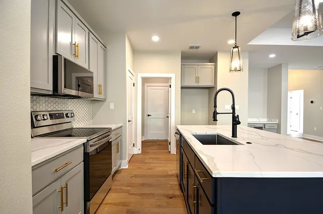 a kitchen with a sink stainless steel appliances and cabinets