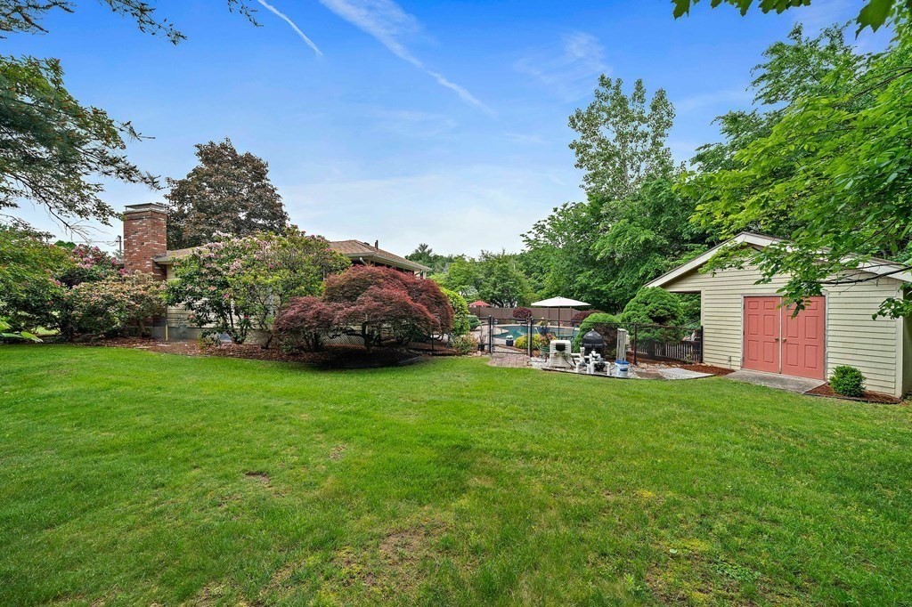 4 Kings Road Canton, MA 02021 - Photo 32 of 33 a backyard of a house with table and chairs plants and large tree
