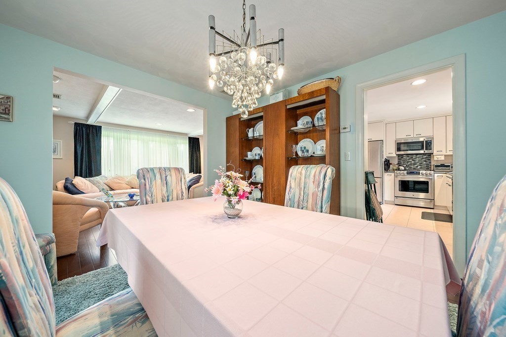 4 Kings Road Canton, MA 02021 - Photo 8 of 33 a large white kitchen with a large island oven a stove and a chandelier