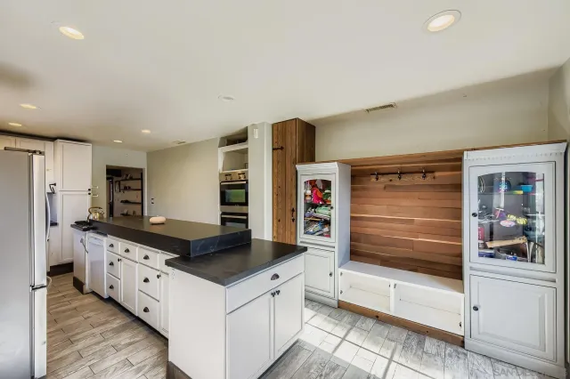 a large white kitchen with a stove a refrigerator and a oven