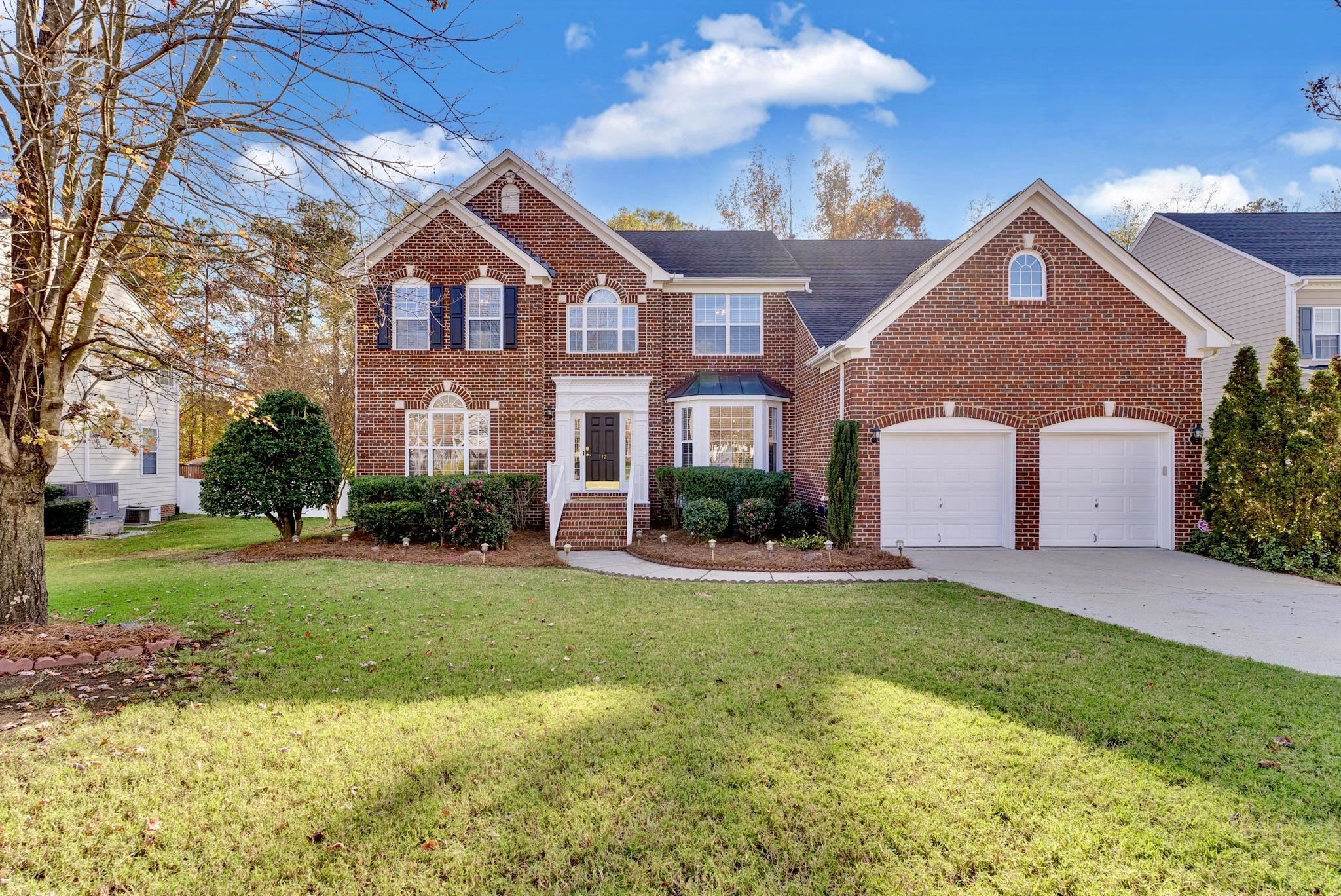 Stunning brick facade with professional landscaping and grassy front yard. Front Elevation