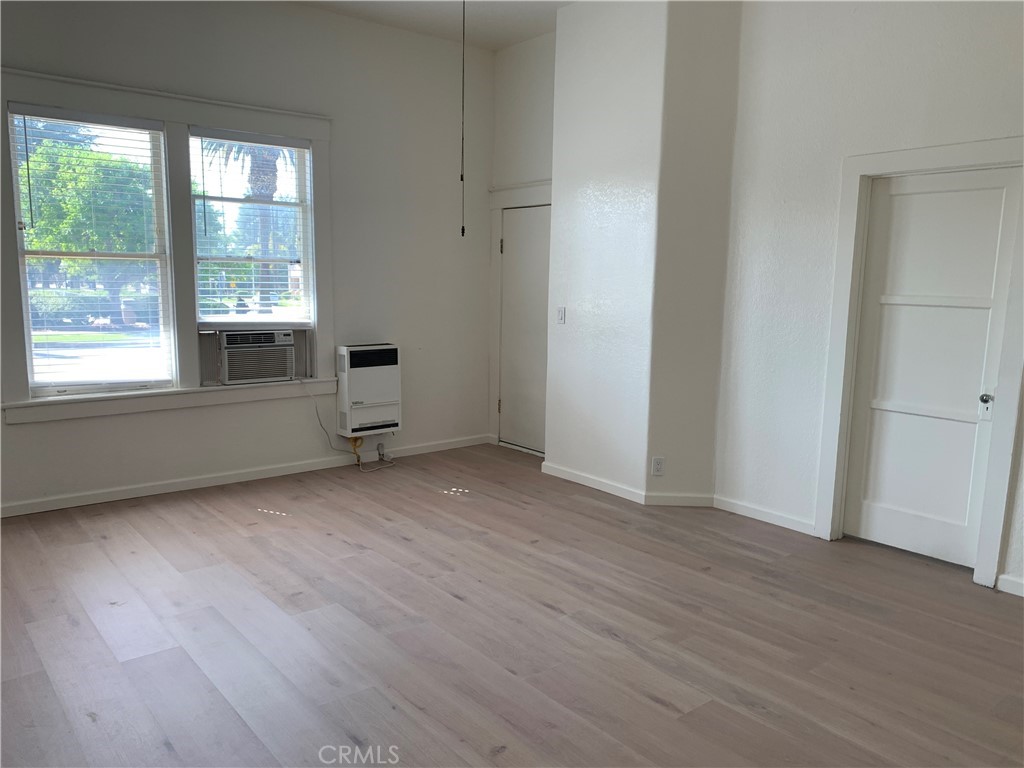 403 Cajon Street, Unit 5 Redlands, CA 92373 - Photo 13 of 16 an empty room with wooden floor and windows