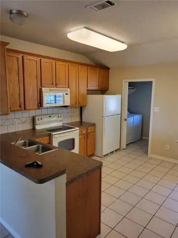 a kitchen with a refrigerator sink and cabinets