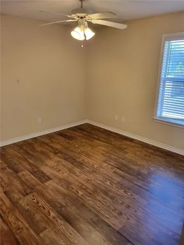 a view of empty room with wooden floor and window