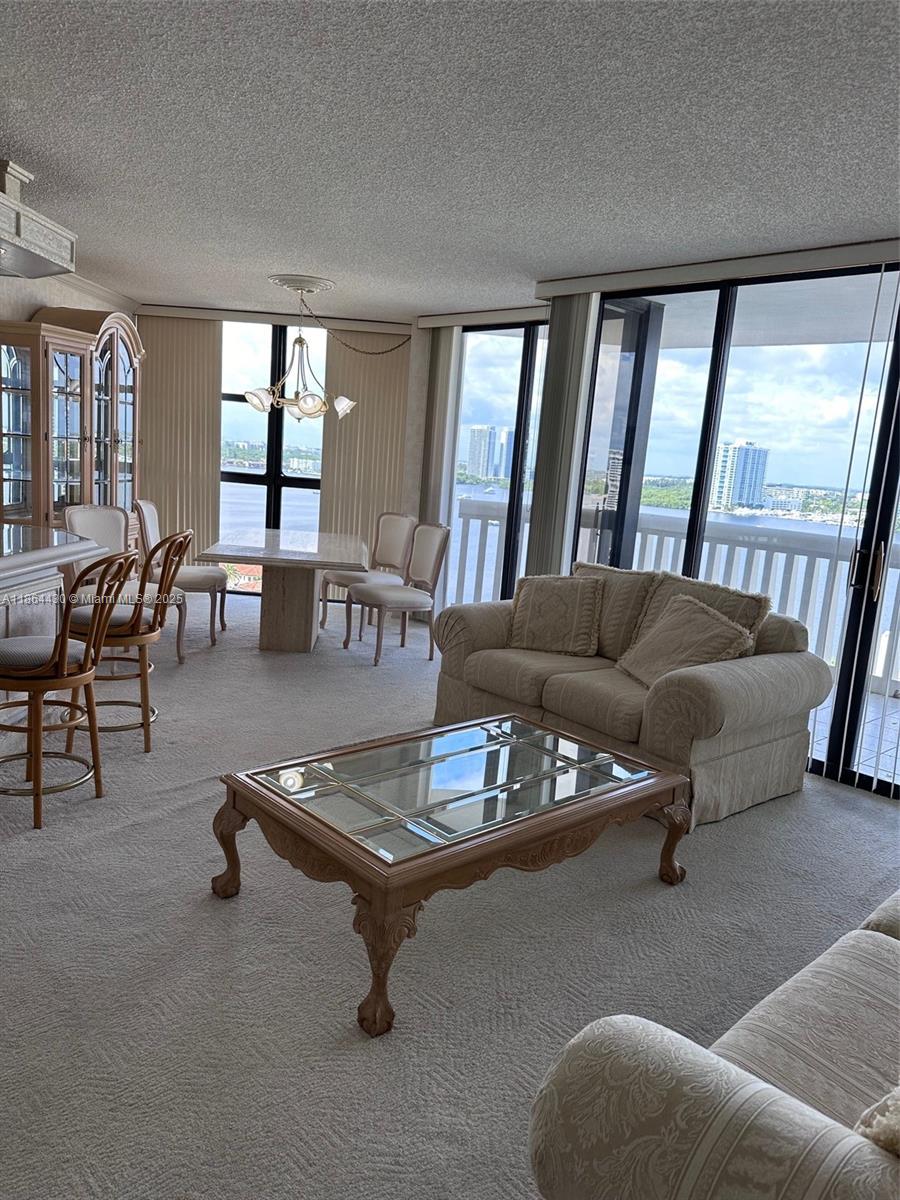 1000 West Island Boulevard, Unit 1511 Aventura, FL 33160 - Photo 6 of 41 a living room with furniture and a potted plant