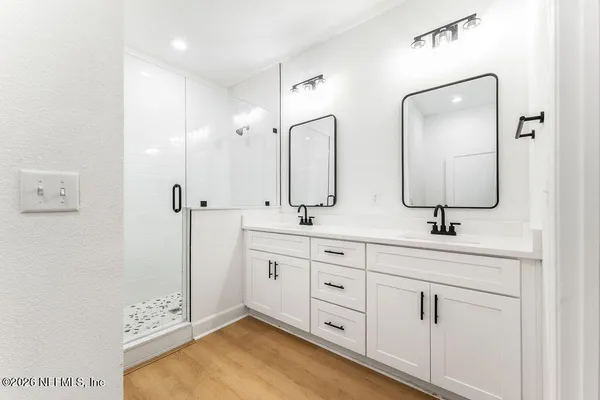 a bathroom with double sink and a mirror