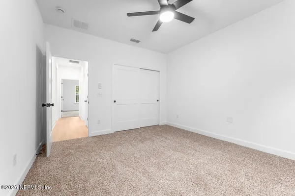 an empty room with fan and entrance