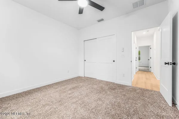 an empty room with an entryway and wooden floor
