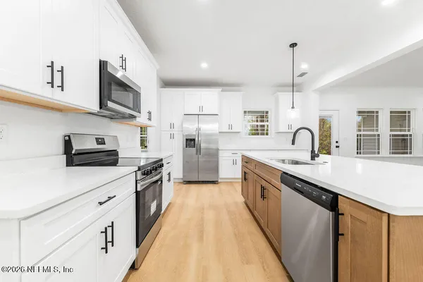 a kitchen with stainless steel appliances a sink stove and cabinets