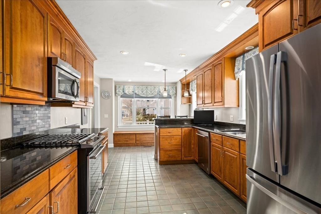 7 Primmett Lane, Unit 7 Worcester, MA 01609 - Photo 7 of 38 a kitchen with stainless steel appliances granite countertop a refrigerator a sink dishwasher a stove and white cabinets with wooden floor
