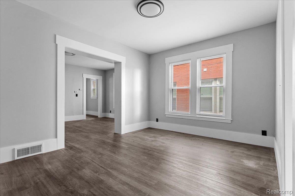58 East Philadelphia Street Detroit, MI 48202 - Photo 9 of 24 Interior room featuring wood-finish flooring, light gray wall paint, and white trim