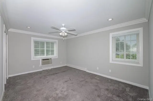 an empty room with chandelier fan and windows