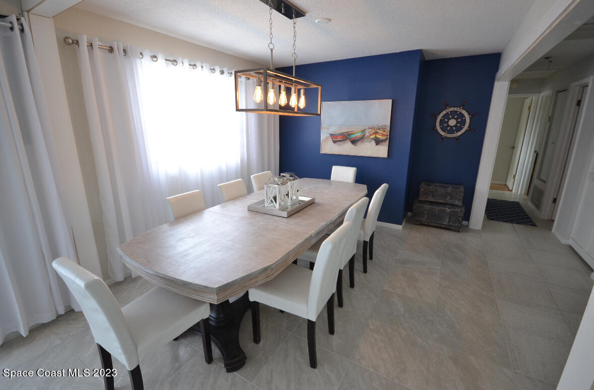 2785 Locksley Road Melbourne, FL 32935 - Photo 20 of 34 a view of a dining room with furniture and chandelier