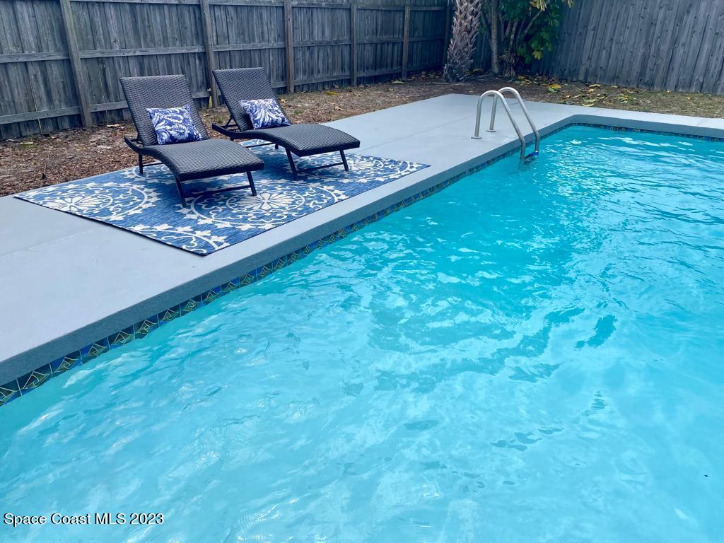 2785 Locksley Road Melbourne, FL 32935 - Photo 5 of 34 a view of a backyard with a tub chairs and wooden fence