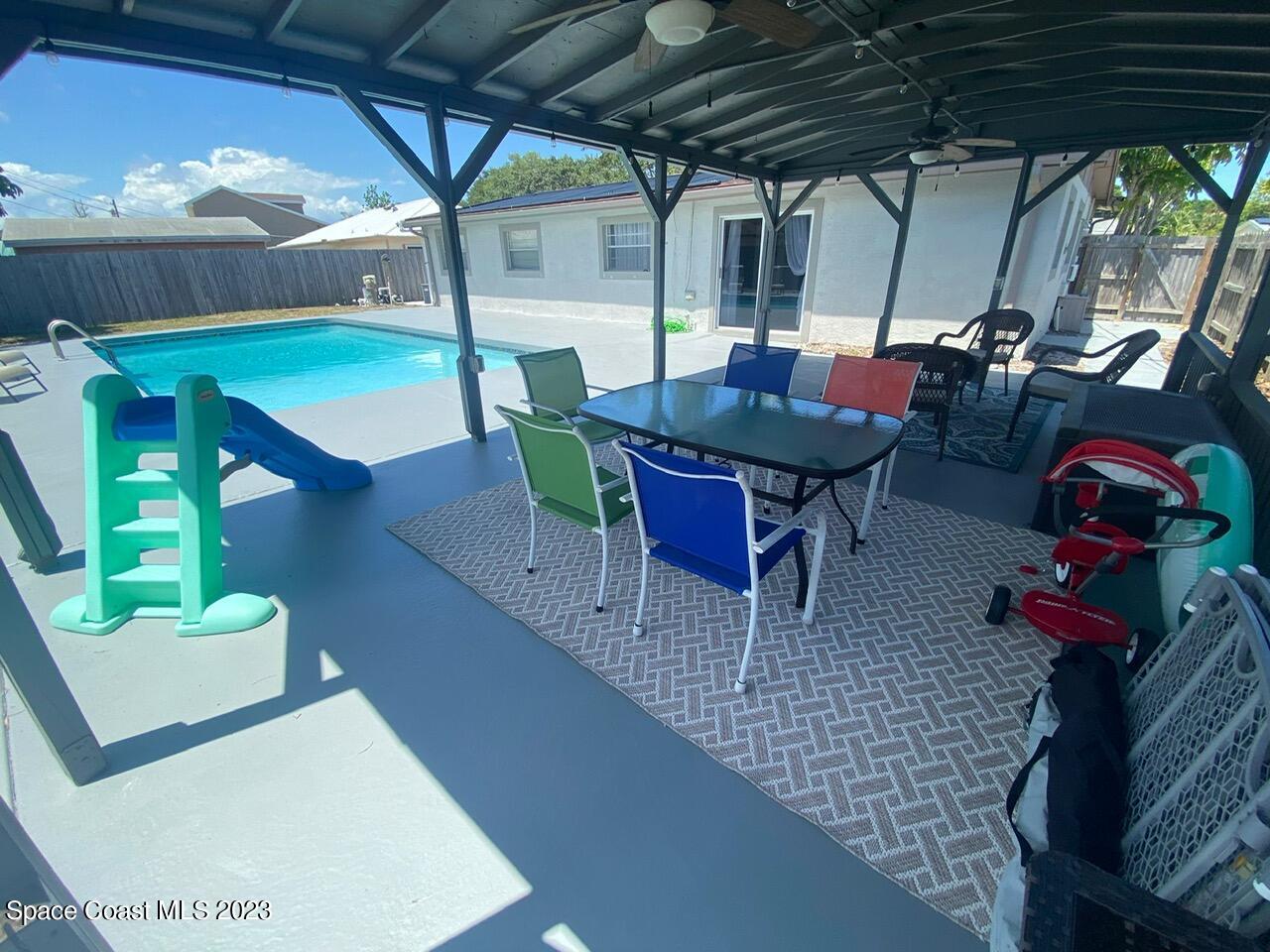 2785 Locksley Road Melbourne, FL 32935 - Photo 6 of 34 a view of a patio with table and chairs potted plants with wooden floor