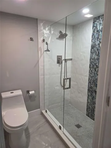 a bathroom with a granite countertop toilet a sink and shower