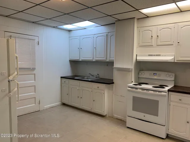 a kitchen with white cabinets and white appliances
