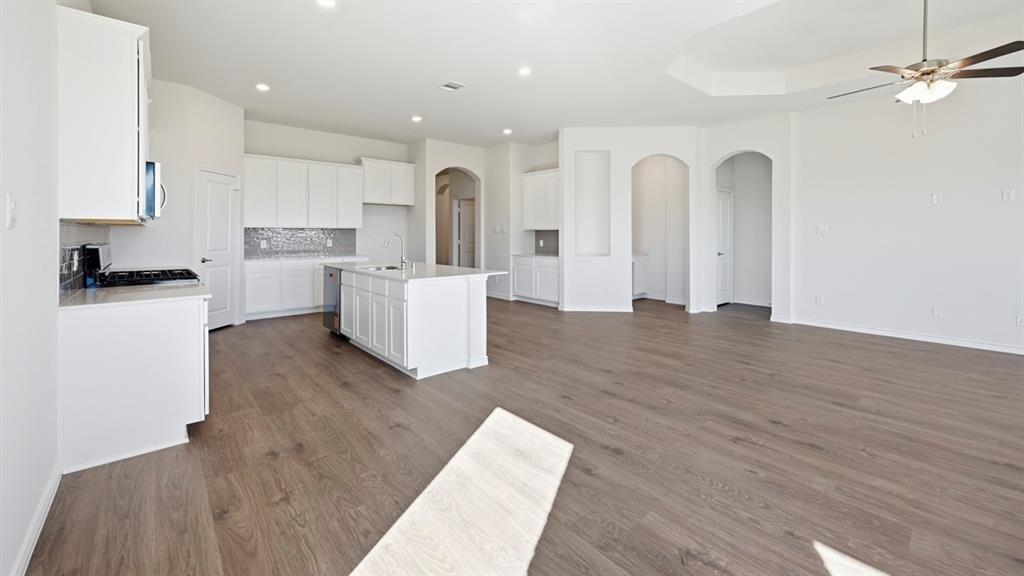 4163 Waldron Trail Forney, TX 75126 - Photo 7 of 30 Open-concept living area featuring wood-finish flooring, recessed lighting, and a tray ceiling with a ceiling fan