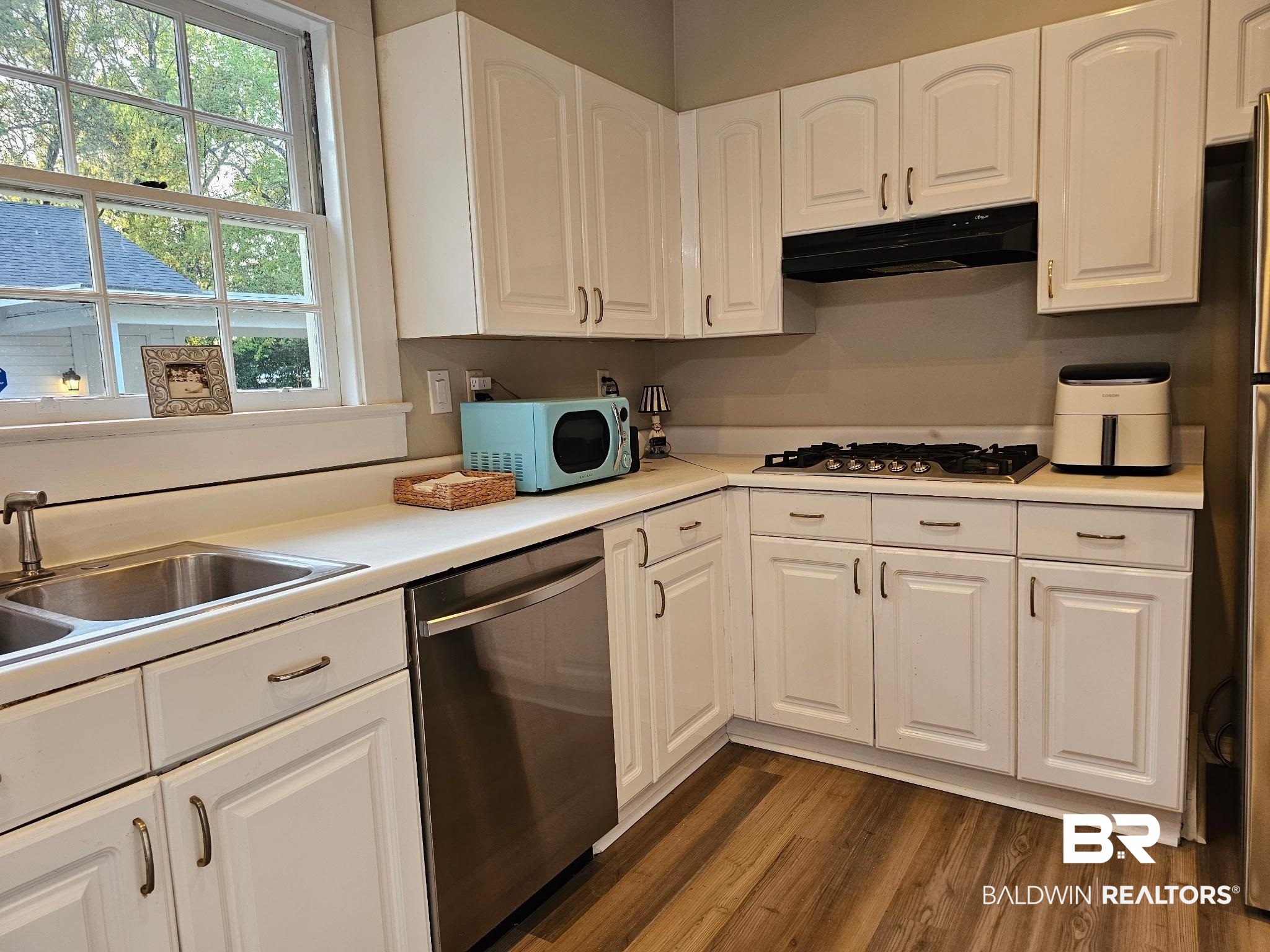1215 Church Street Mobile, AL 36604 - Photo 5 of 23 Kitchen with dark wood-style floors, white cabinetry, under cabinet range hood, and stainless steel appliances