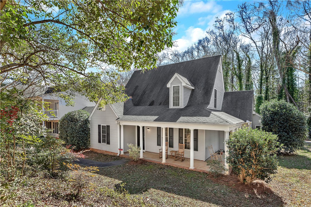 This charming home offers a welcoming facade with a covered porch and dormer windows.