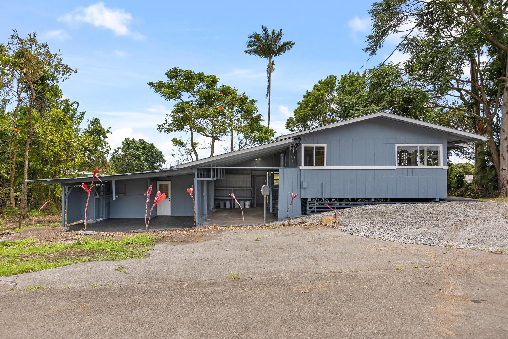 446 Ainaola Drive Hilo, HI 96720 - Photo 19 of 30 a backyard of a house with potted plants and palm trees