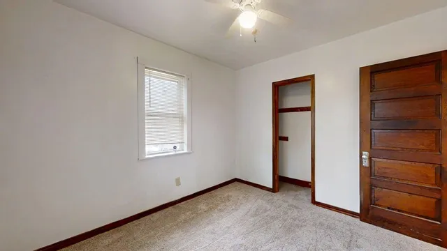 an empty room with windows and closet