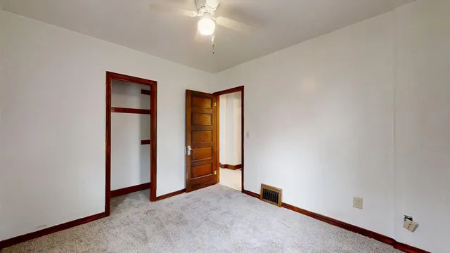 an empty room with closet and windows
