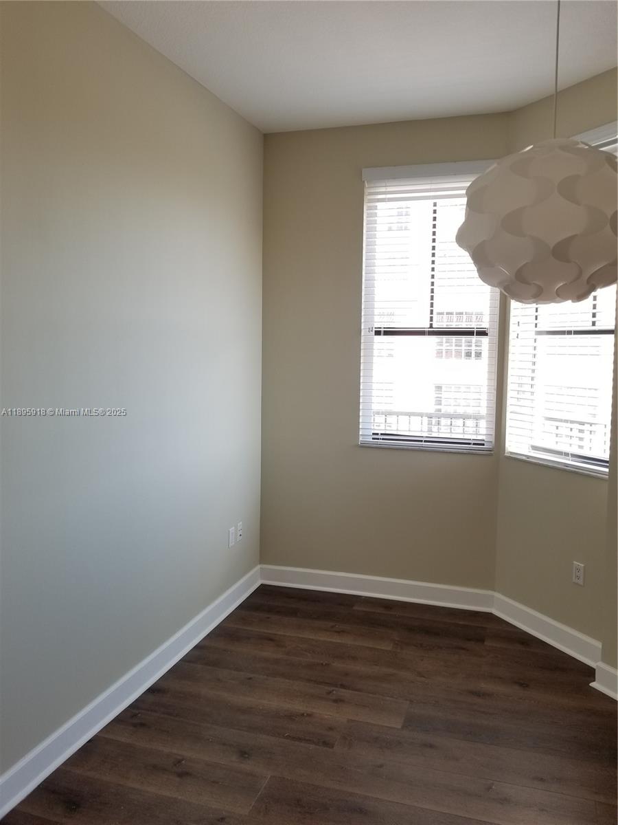 55 Merrick Way, Unit 828 Coral Gables, FL 33134 - Photo 13 of 17 a view of an empty room with wooden floor and a window