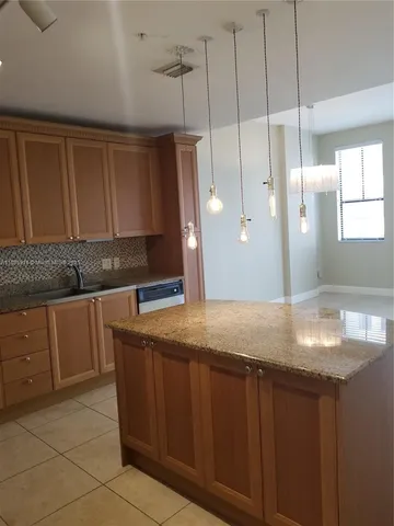 a kitchen with granite countertop a sink and a cabinets