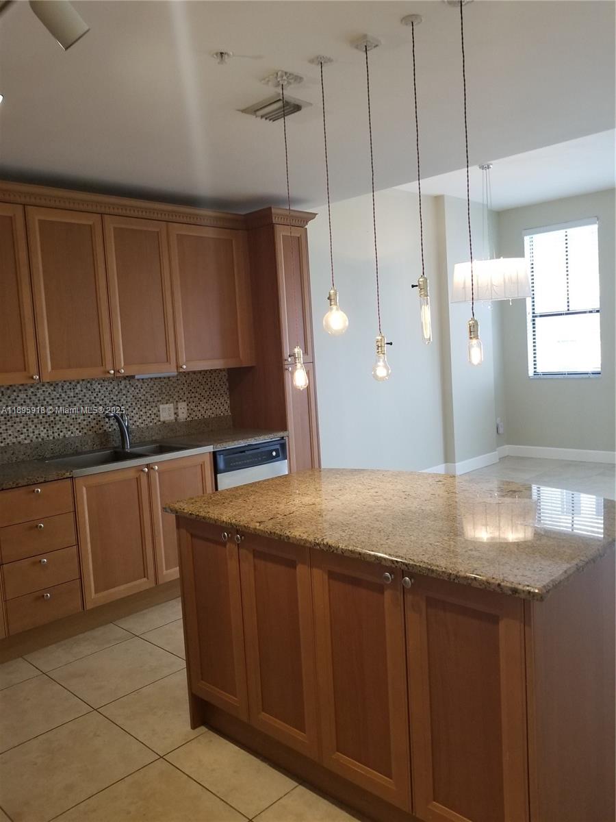 55 Merrick Way, Unit 828 Coral Gables, FL 33134 - Photo 10 of 17 a kitchen with granite countertop a sink and a cabinets