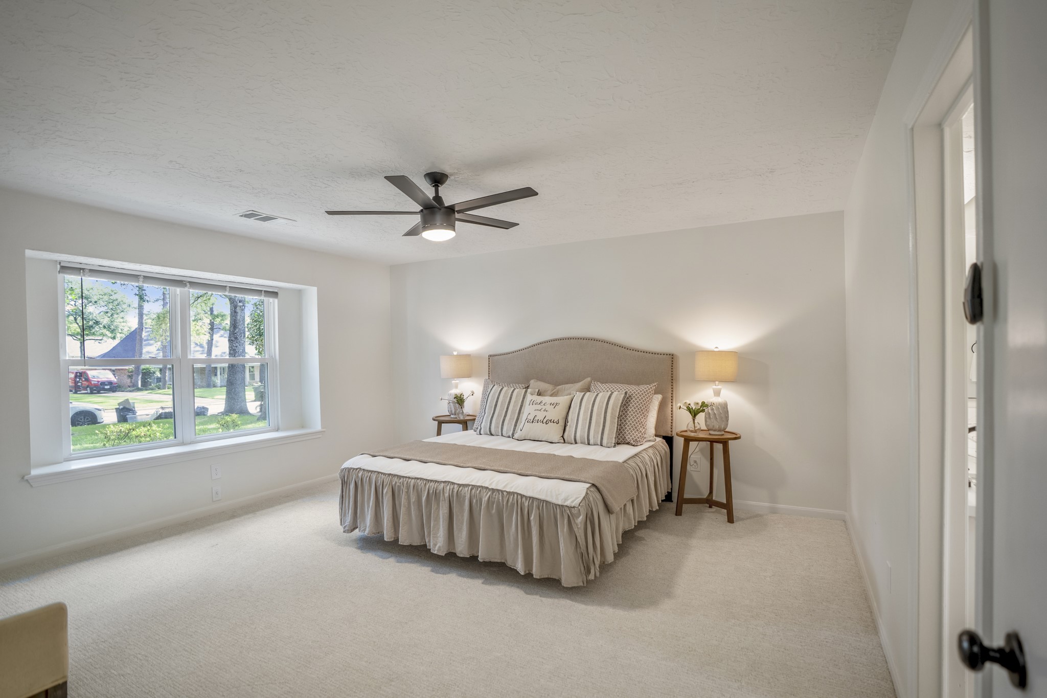 6303 Larkmount Drive Spring, TX 77389 - Photo 21 of 50 Tucked just off the family room for added privacy, the downstairs primary suite offers a calm retreat at the end of the day. Fresh carpet, updated paint, and the large window filling the room with natural light help the space feel bright, comfortable, and easy to unwind in.